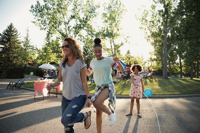 Two young women happily skipping rope together