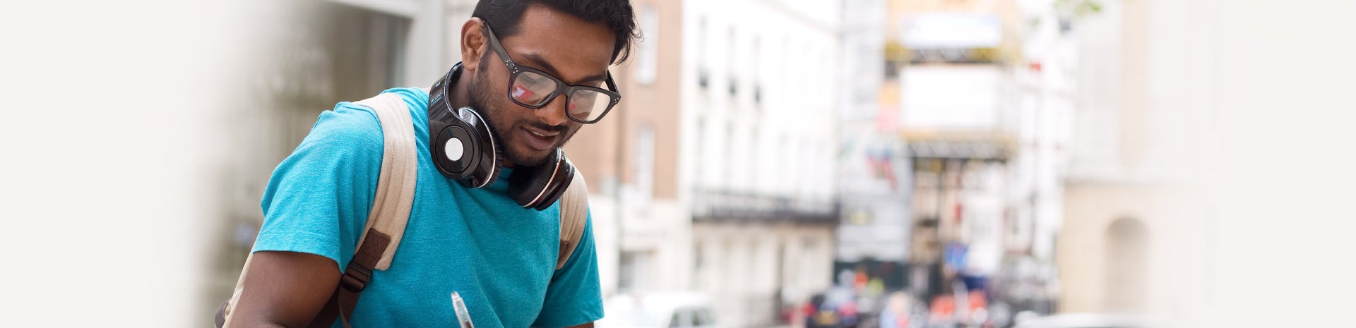 A young man with headphones and backpack