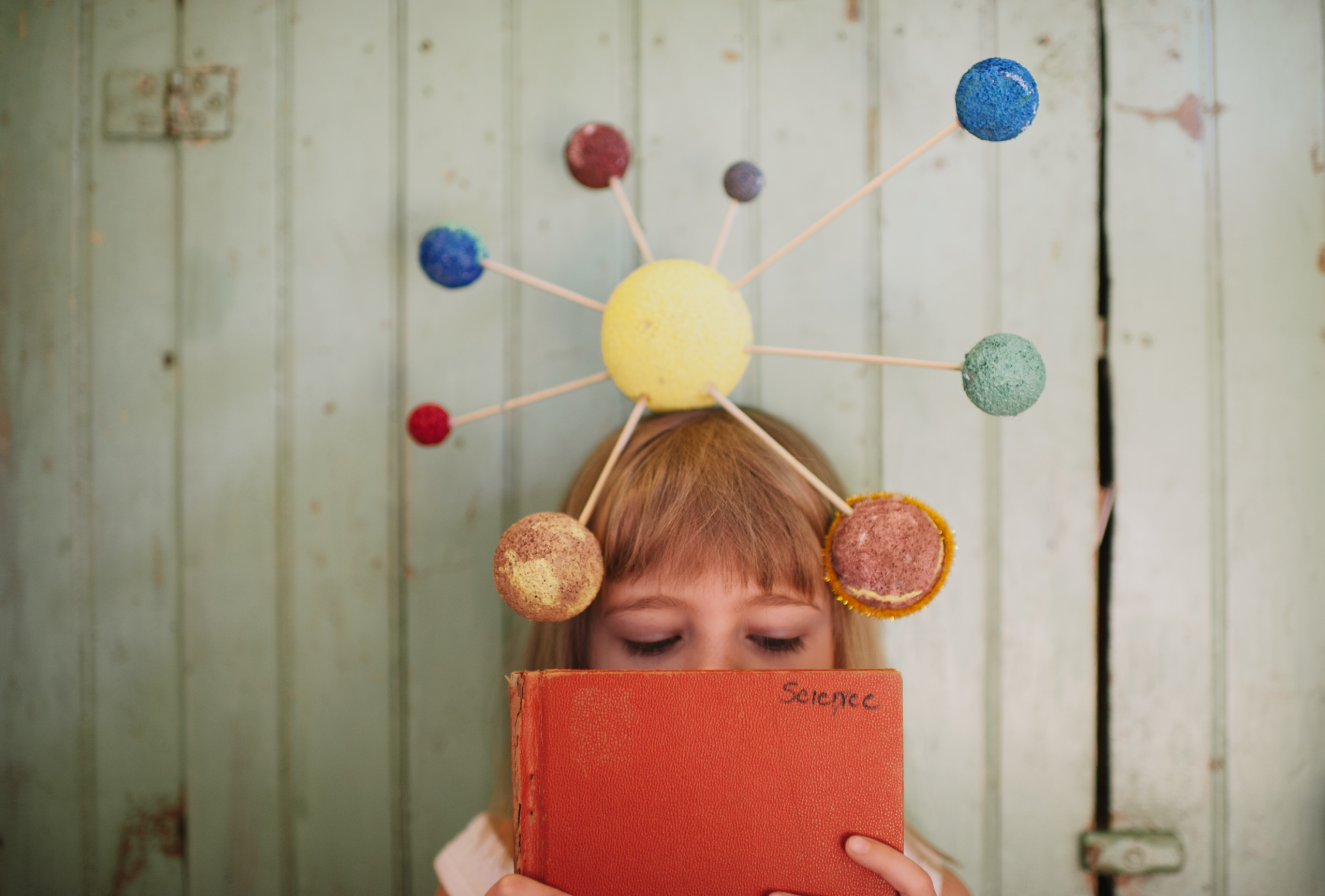 Girl playing with crafted solar system