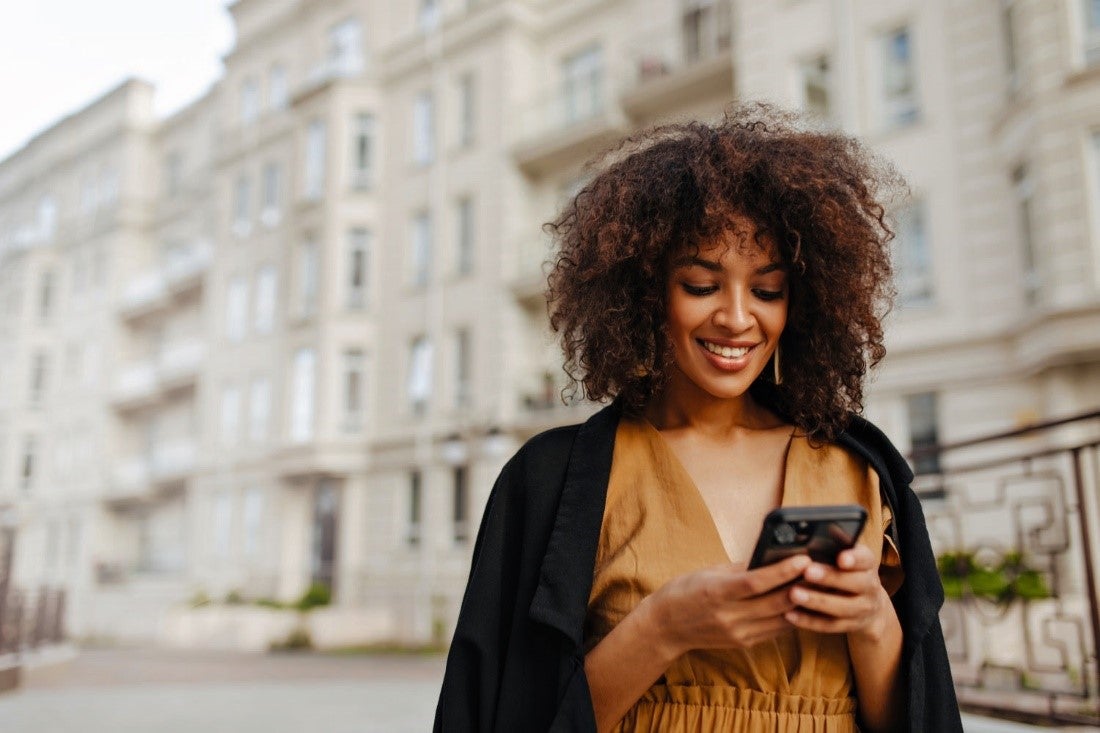 Lady with a smile looking over her phone mobile