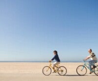 Couple cycling on a sea beach
