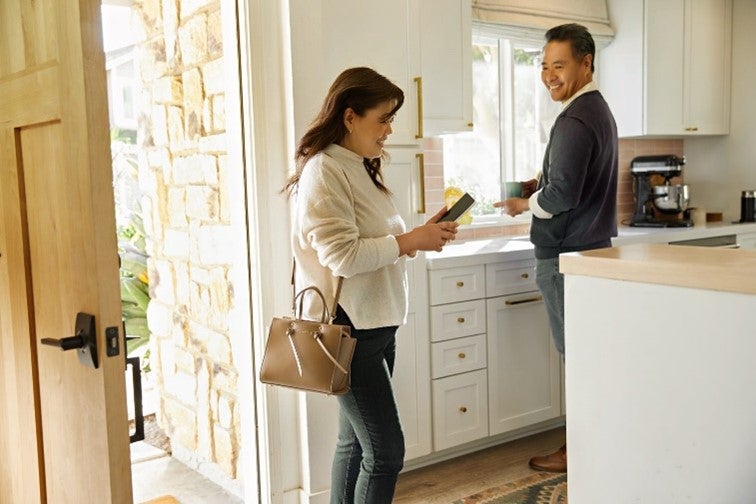 Man looking at a lady with a phone in kitchen