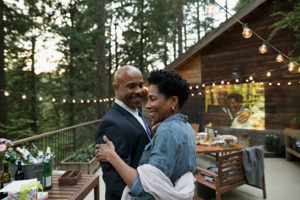 Couple celebrating anniversary on a the deck of a wooden cottage