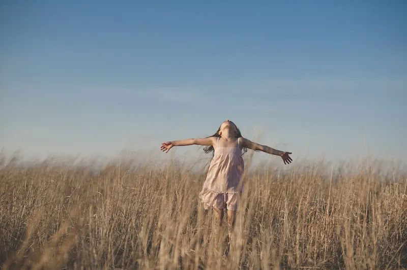 Women wearing pink dress is spinning in a field