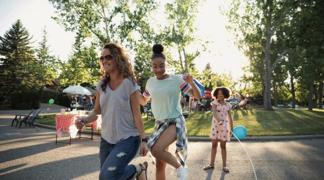 Two young women happily skipping rope together